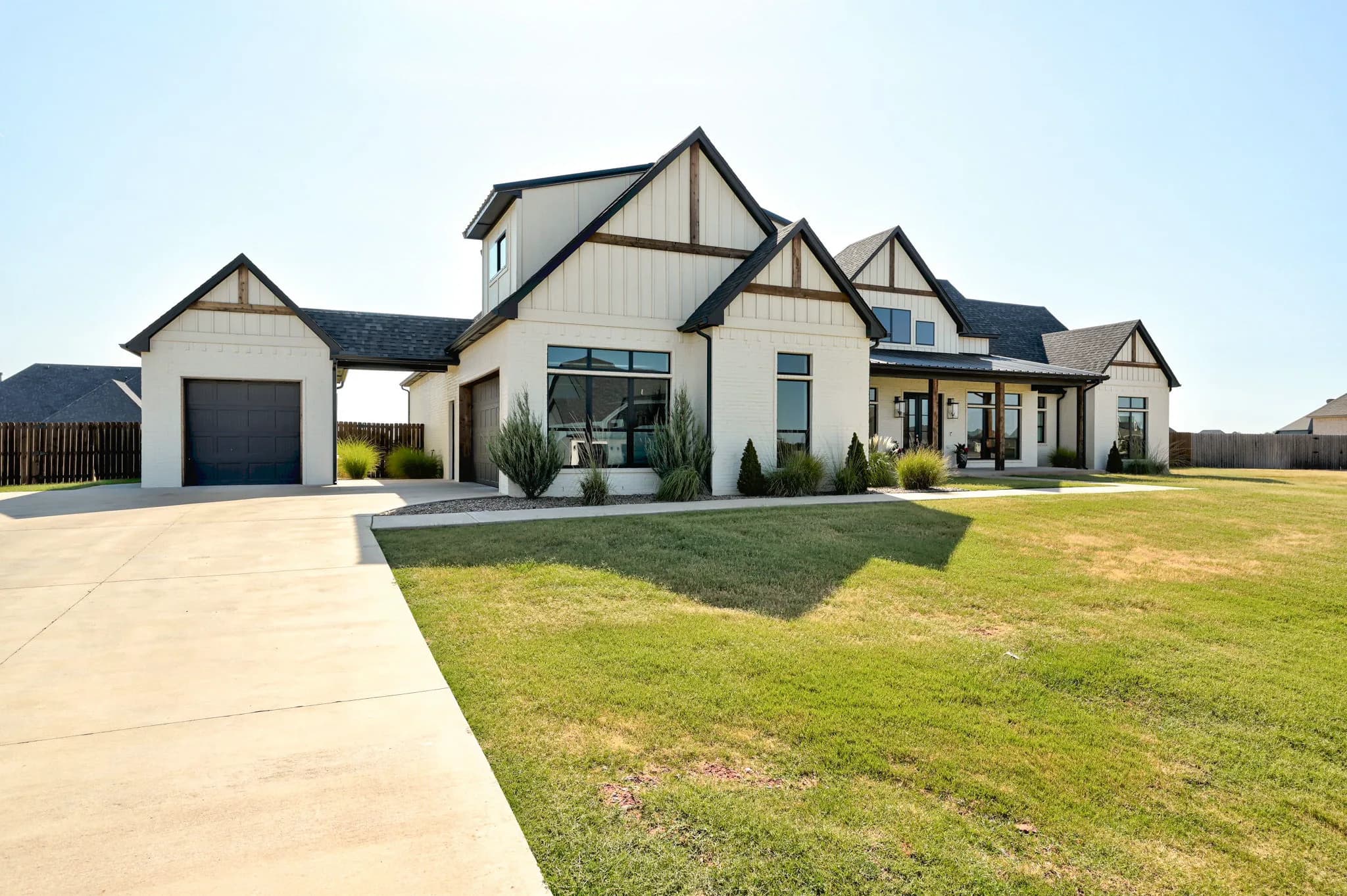 Angled front view of 1034 Acclivis Way showing the attached and detached garages along the concrete driveway