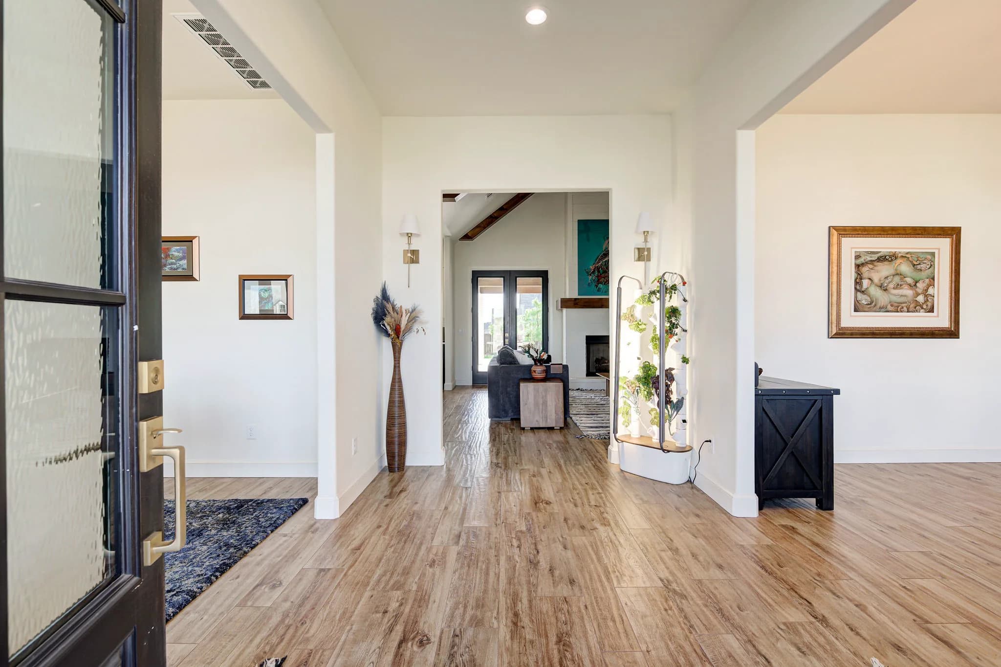 Entry foyer with wood-look tile floors opening toward the living room and fireplace