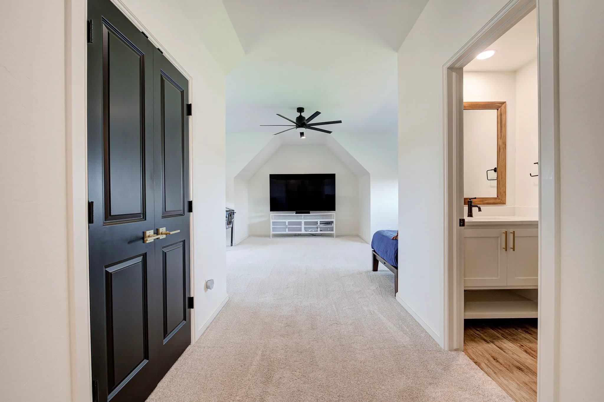 Upstairs bonus room with a vaulted ceiling, carpet, a media area, and an adjoining vanity