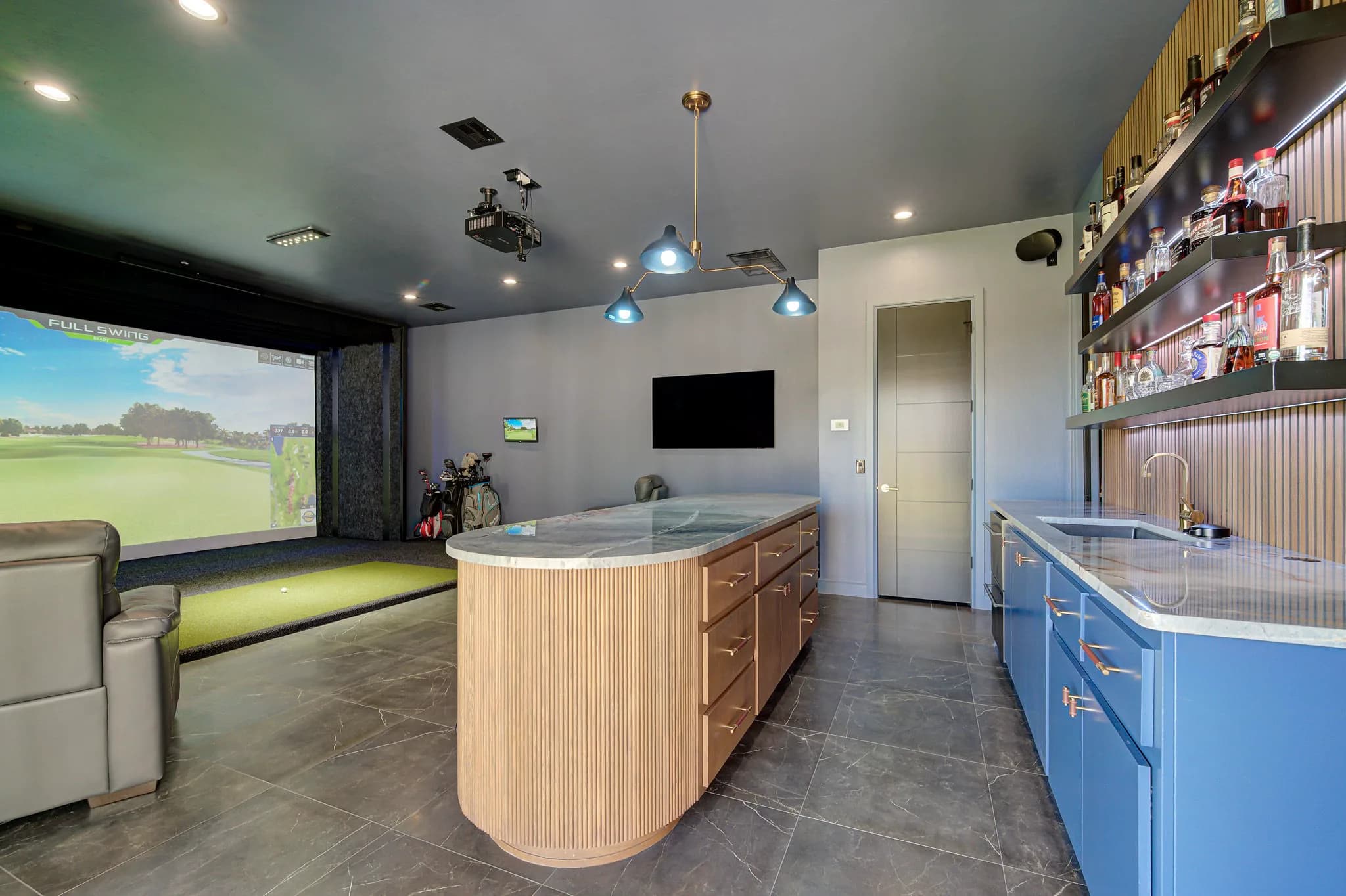 Entertainment building interior with a golf simulator bay, a fluted-wood island, and a custom backlit wet bar