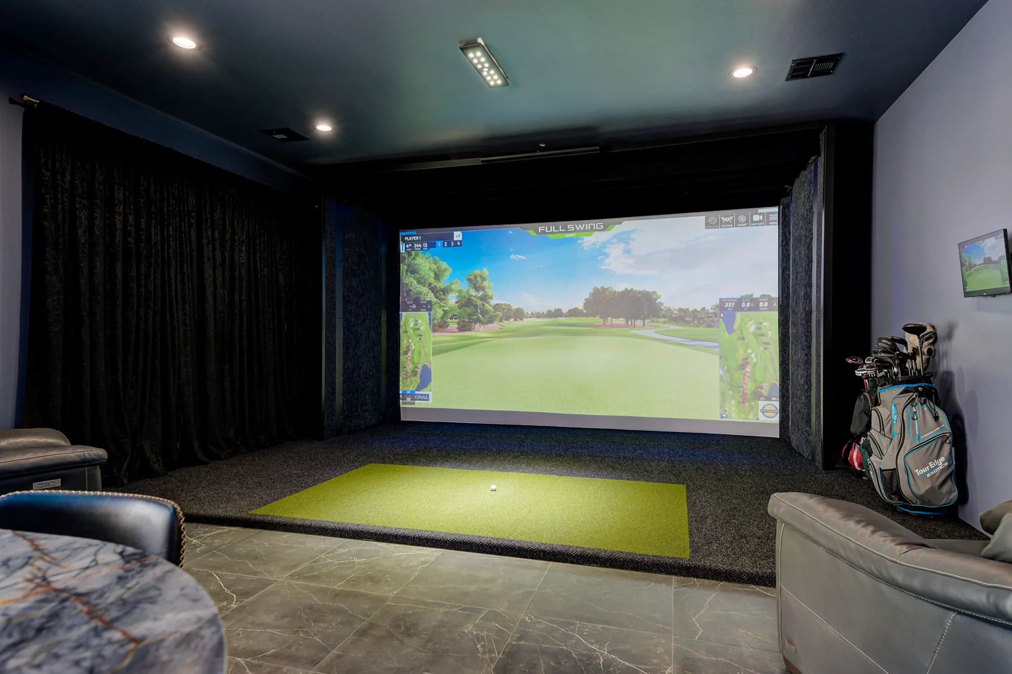 Golf simulator with a full-width projection screen and hitting mat in the detached entertainment building